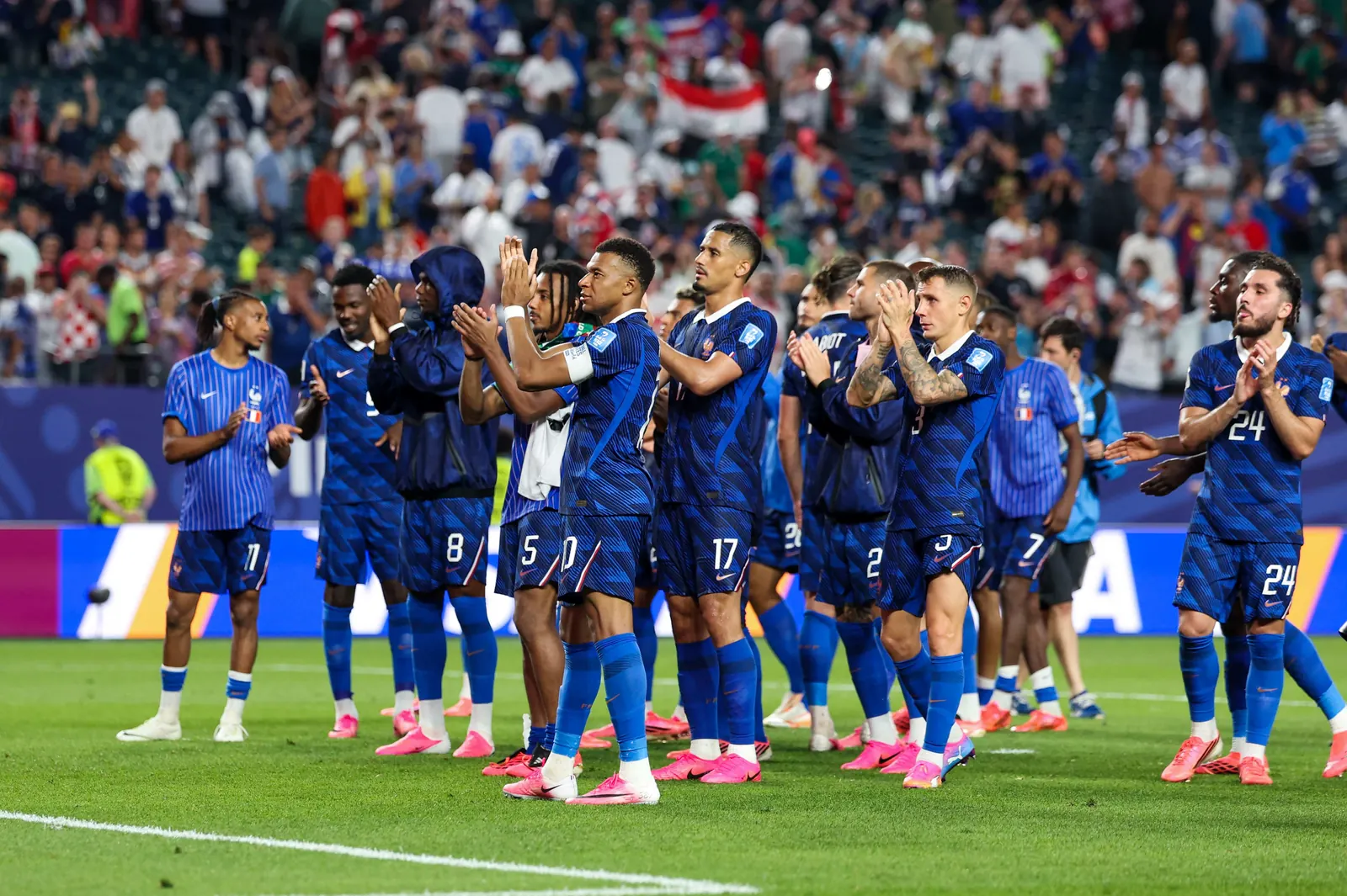 Joueurs de l'équipe de France en maillot bleu applaudissant leurs supporters
